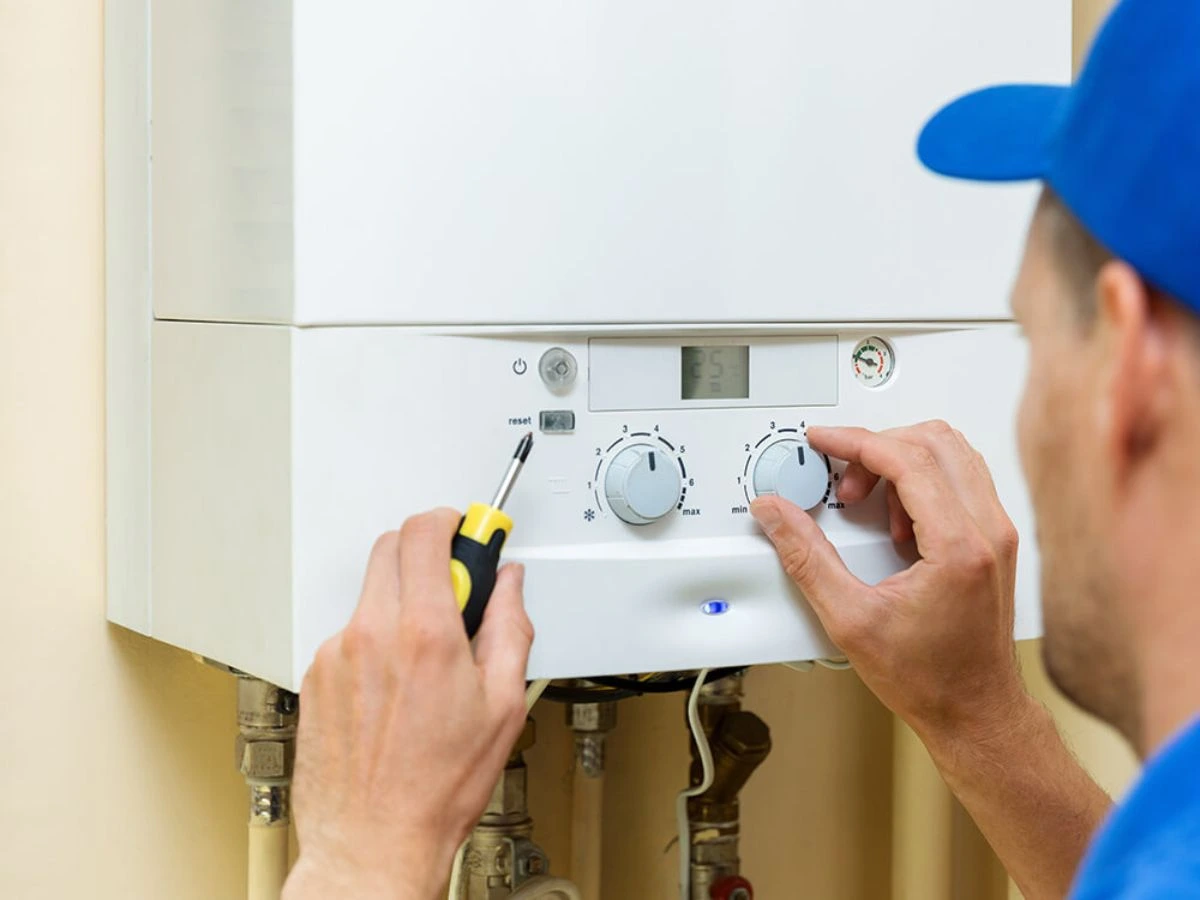 man calibrating the switch of boiler | Premier Gas